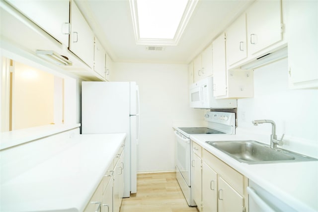 kitchen featuring white appliances, light wood finished floors, visible vents, light countertops, and a sink