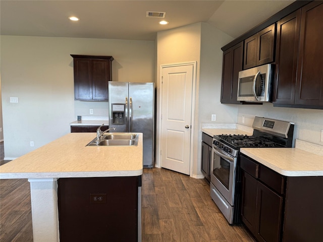 kitchen featuring stainless steel appliances, dark brown cabinets, a sink, and visible vents