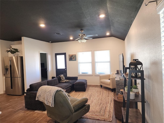 living room featuring lofted ceiling, visible vents, ceiling fan, a textured ceiling, and wood finished floors