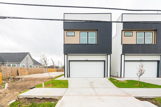 view of front of property featuring a garage, fence, driveway, and stucco siding