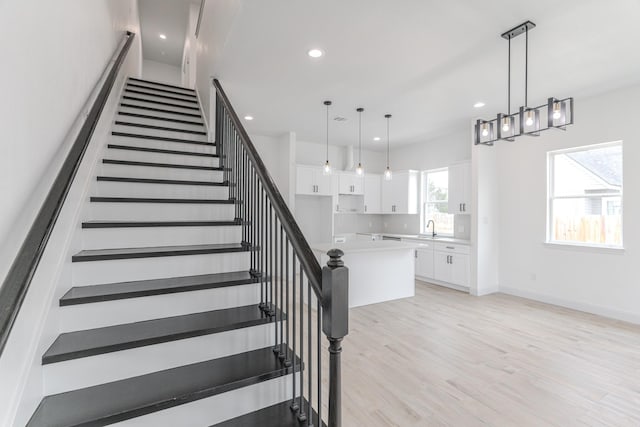 staircase featuring recessed lighting, visible vents, baseboards, and wood finished floors