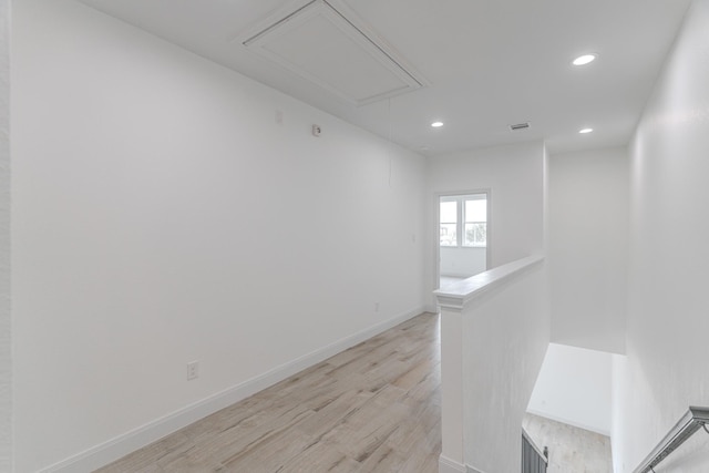 corridor featuring recessed lighting, light wood-style flooring, attic access, an upstairs landing, and baseboards