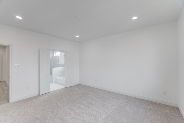 unfurnished bedroom with recessed lighting, light colored carpet, and baseboards