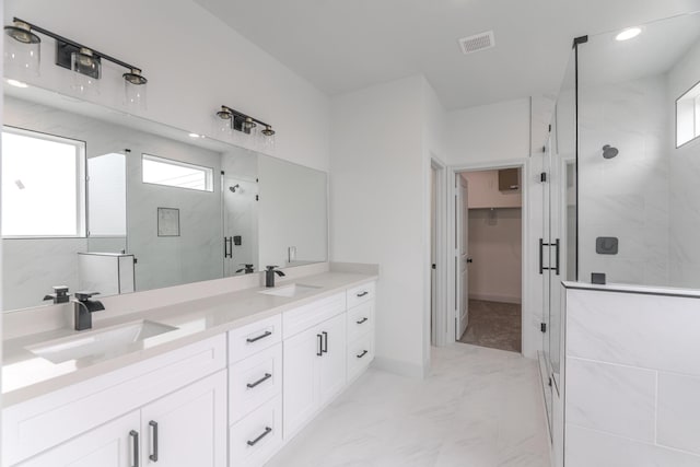 bathroom featuring marble finish floor, visible vents, a sink, and a shower stall