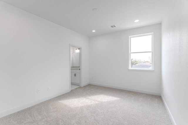 unfurnished room featuring recessed lighting, light colored carpet, visible vents, and baseboards