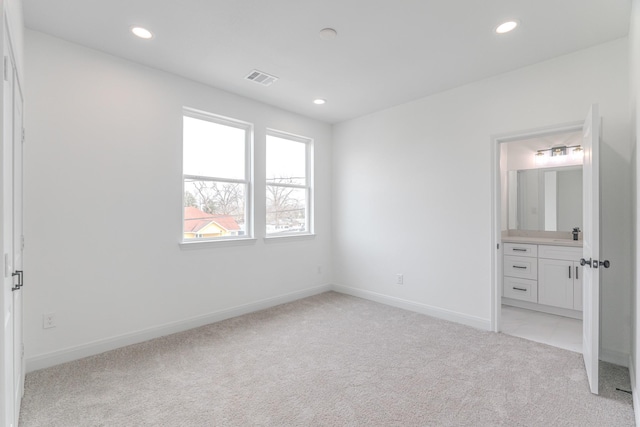 unfurnished bedroom featuring light carpet, baseboards, visible vents, and recessed lighting