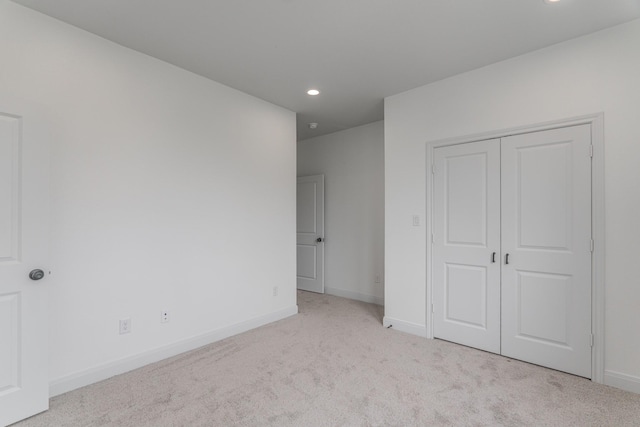 unfurnished bedroom with carpet, a closet, baseboards, and recessed lighting