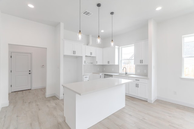 kitchen featuring white cabinetry, a center island, visible vents, and a healthy amount of sunlight