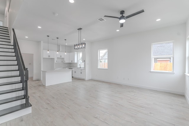 kitchen with open floor plan, white cabinetry, visible vents, and a healthy amount of sunlight