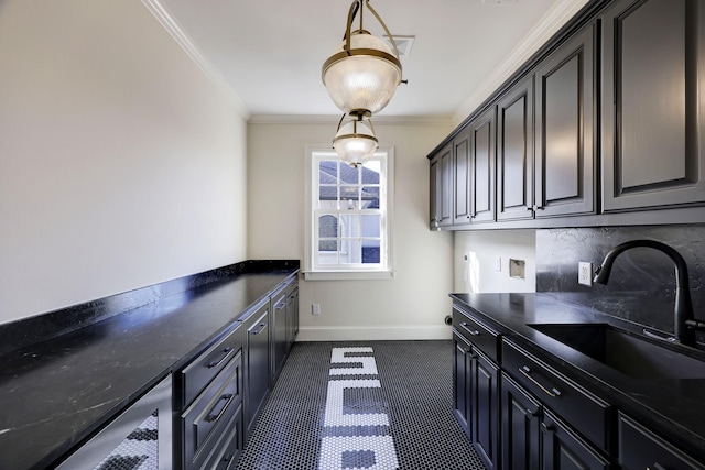 kitchen featuring baseboards, dark countertops, a sink, crown molding, and backsplash