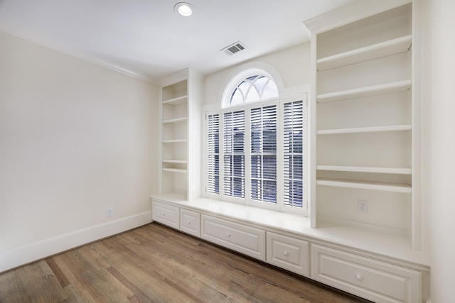 interior space with baseboards, visible vents, wood finished floors, built in shelves, and recessed lighting