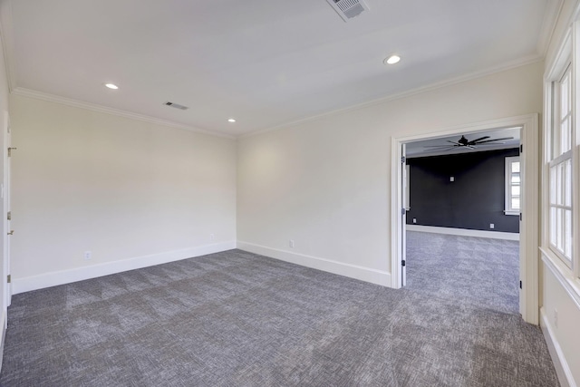 unfurnished room featuring carpet floors, visible vents, crown molding, and baseboards