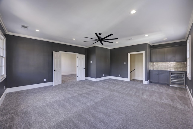 unfurnished bedroom featuring baseboards, wine cooler, visible vents, and carpet flooring