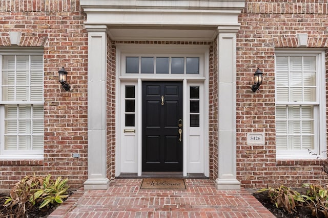 entrance to property featuring brick siding