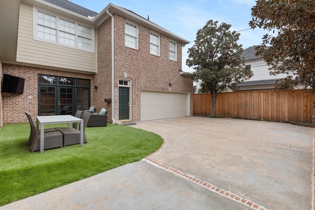 view of front of property featuring a garage, brick siding, fence, driveway, and french doors