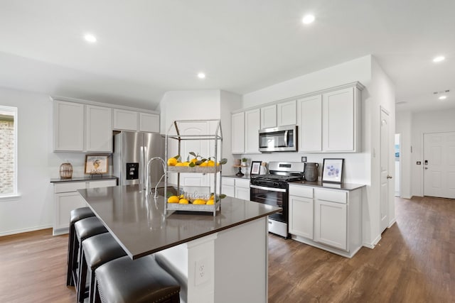 kitchen with dark countertops, appliances with stainless steel finishes, a sink, and recessed lighting