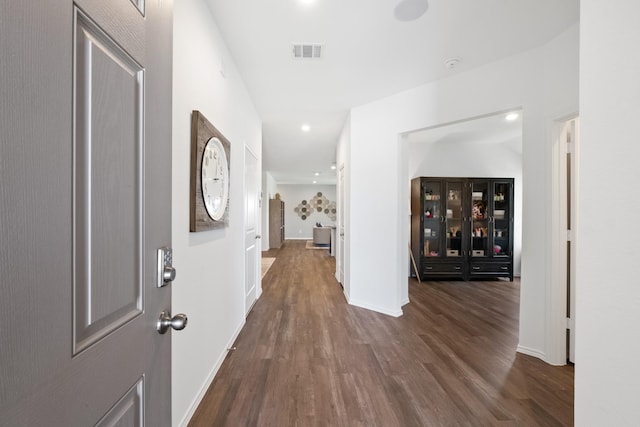 interior space featuring baseboards, visible vents, dark wood finished floors, and recessed lighting