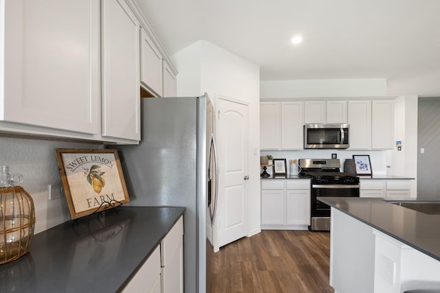 kitchen featuring stainless steel appliances, dark countertops, white cabinets, and dark wood-style floors