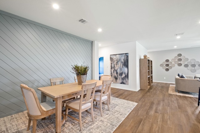 dining space with baseboards, wood finished floors, visible vents, and recessed lighting