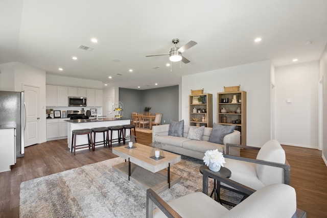 living room with ceiling fan, recessed lighting, dark wood-type flooring, visible vents, and baseboards