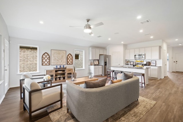 living area featuring light wood-style flooring, visible vents, a ceiling fan, and recessed lighting