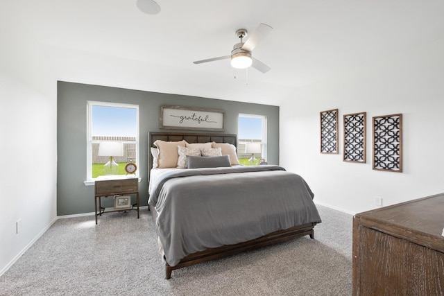 bedroom featuring multiple windows, baseboards, and a ceiling fan