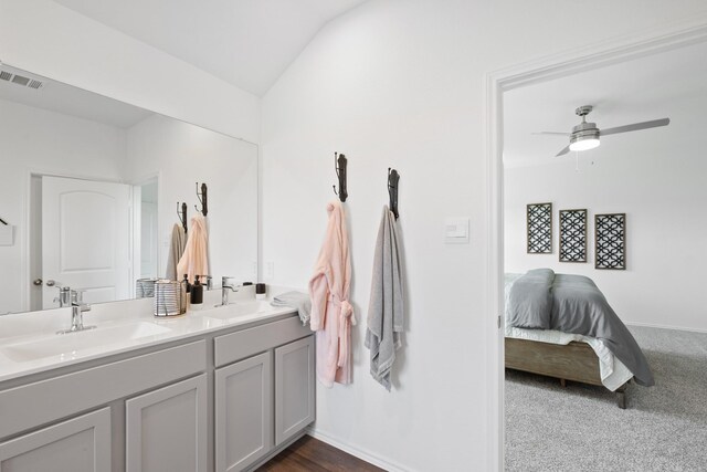 ensuite bathroom with ceiling fan, visible vents, a sink, and double vanity