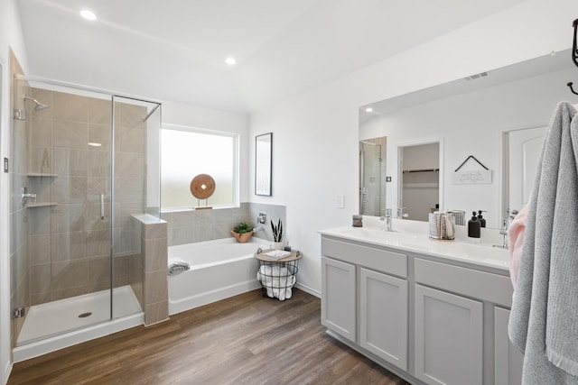 full bath with double vanity, visible vents, wood finished floors, a shower stall, and a bath