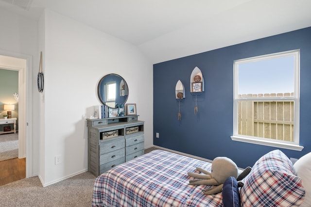 bedroom with carpet, multiple windows, vaulted ceiling, and visible vents