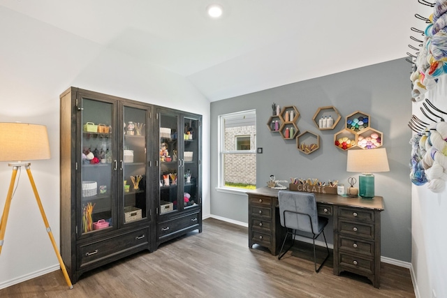 home office featuring lofted ceiling, baseboards, and wood finished floors