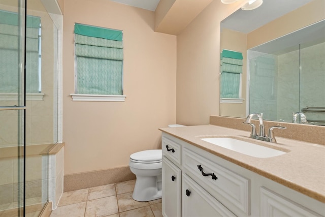 full bath featuring toilet, a shower with shower door, vanity, baseboards, and tile patterned floors