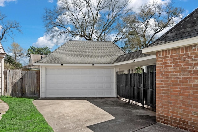 garage featuring fence and driveway