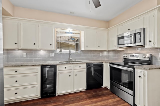 kitchen featuring wine cooler, a sink, appliances with stainless steel finishes, backsplash, and light stone countertops