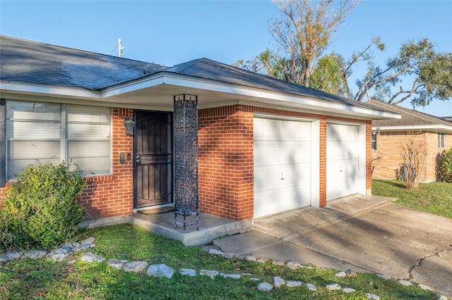 exterior space featuring a garage, concrete driveway, brick siding, and a shingled roof