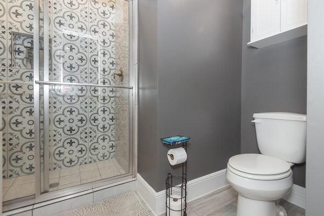 full bath featuring a shower stall, toilet, and baseboards