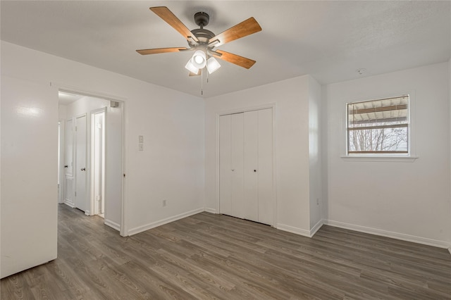 unfurnished bedroom with a ceiling fan, a closet, baseboards, and wood finished floors