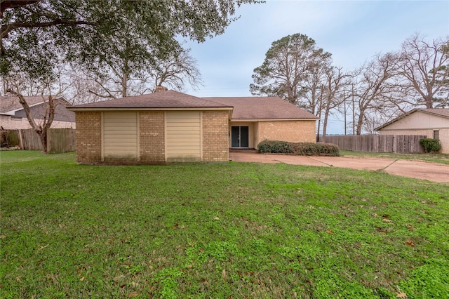 ranch-style home featuring brick siding, a front yard, and fence