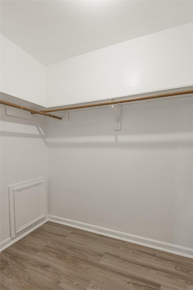 walk in closet with wood finished floors