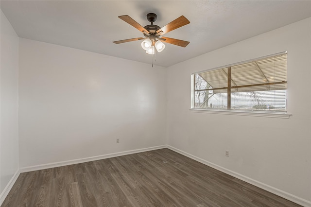 spare room with dark wood-style floors, baseboards, and a ceiling fan