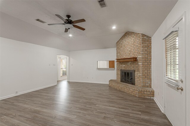 unfurnished living room with vaulted ceiling, wood finished floors, visible vents, and a ceiling fan