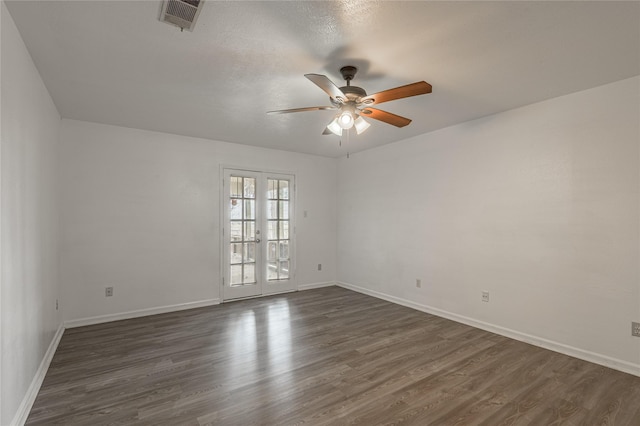 empty room featuring ceiling fan, visible vents, dark wood-type flooring, and french doors