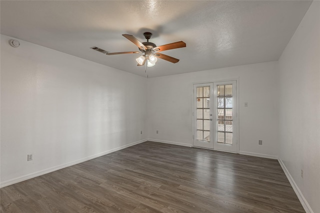 spare room featuring french doors, dark wood finished floors, visible vents, ceiling fan, and baseboards