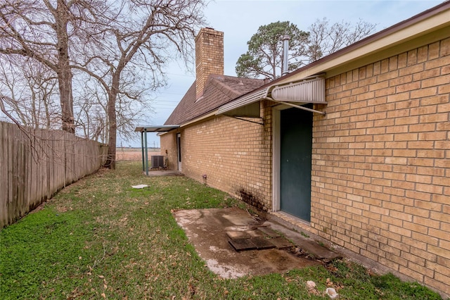 view of yard with central AC unit and fence