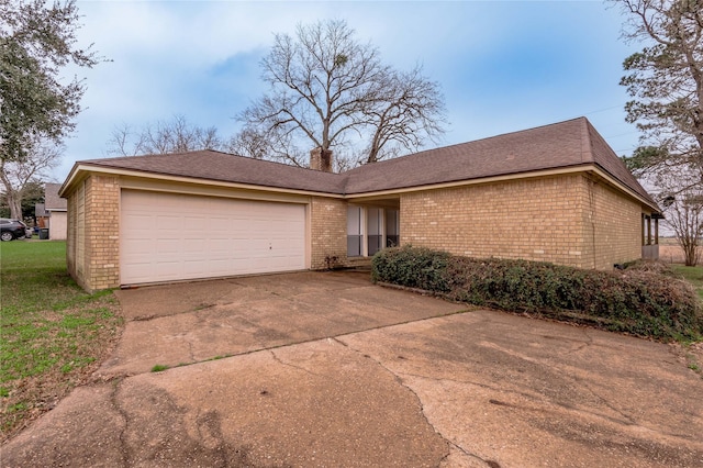 single story home featuring driveway, an attached garage, a chimney, and brick siding