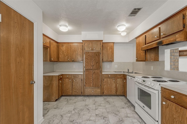 kitchen featuring marble finish floor, light countertops, visible vents, brown cabinetry, and white appliances