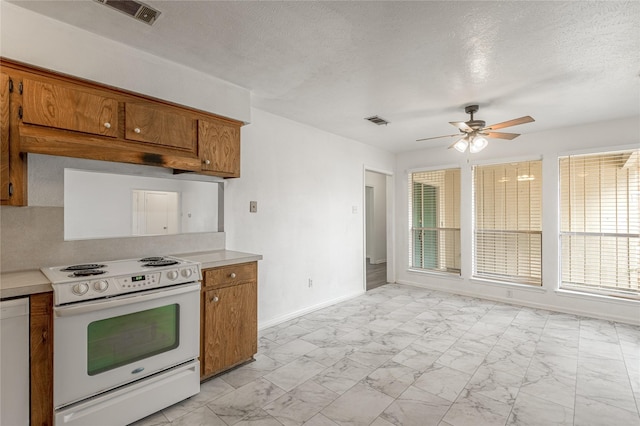 kitchen featuring marble finish floor, visible vents, brown cabinetry, and white range with electric cooktop