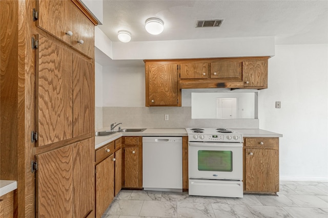 kitchen with brown cabinetry, white appliances, visible vents, and marble finish floor