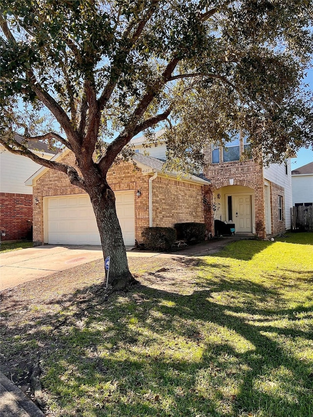 view of front facade featuring a front yard, brick siding, driveway, and an attached garage