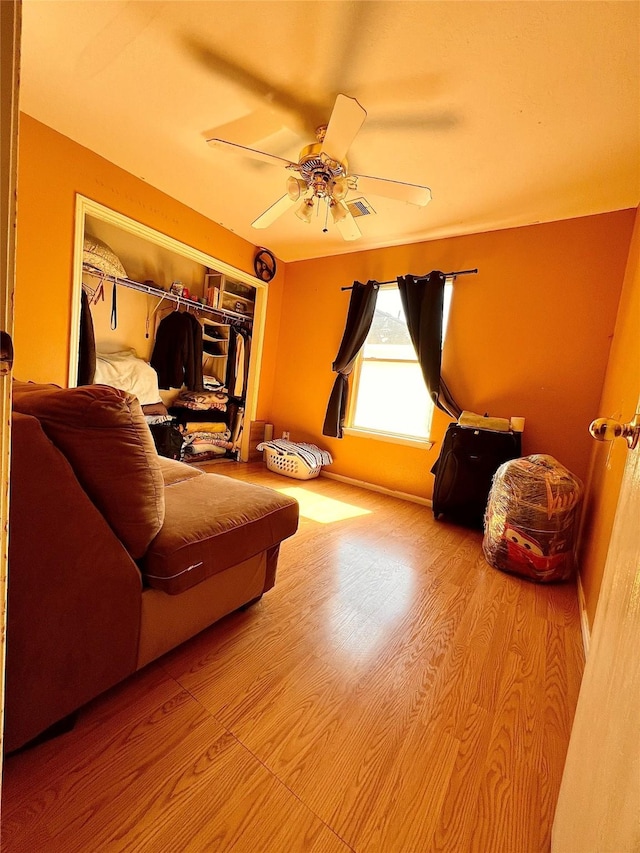 living room with ceiling fan, wood finished floors, and baseboards