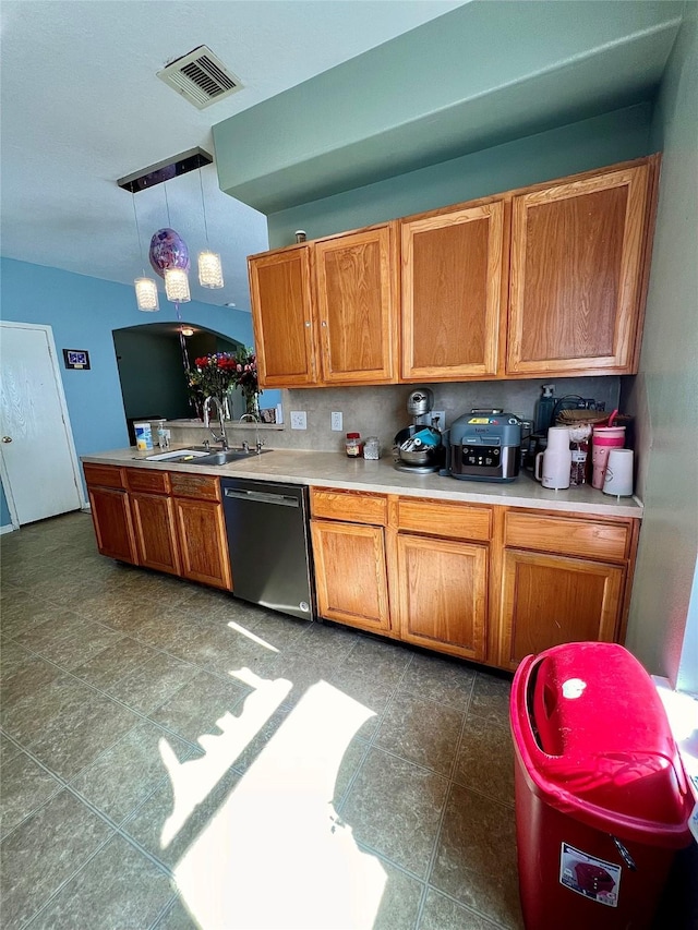 kitchen with a sink, visible vents, light countertops, stainless steel dishwasher, and brown cabinets